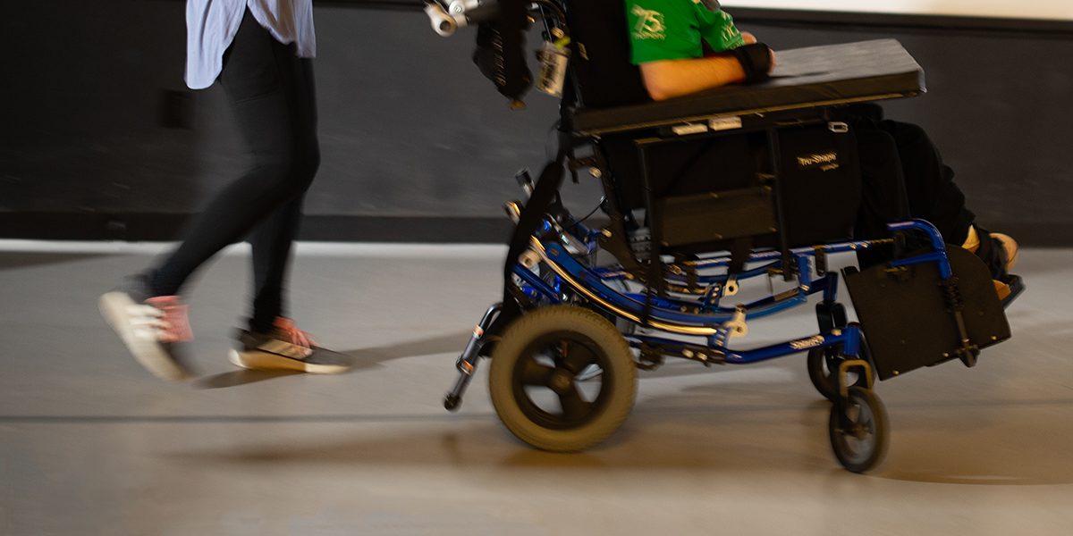 Wheelchair participant on stage celebrating music, movement, and outrageous creativity.