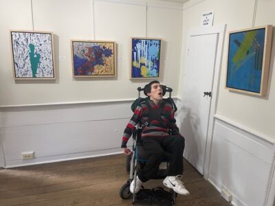 Artist Anthony Zaccaria with exhibited paintings in the Farmstead Arts gallery.