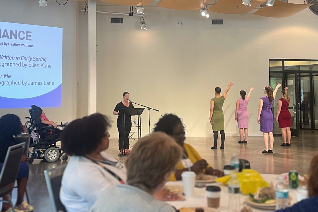 Four dancers performing an original work by choreographer Ellen Kane with Performing Arts Coordinator Heather Williams providing introductions for The Cultural Access Network Project in 2023.