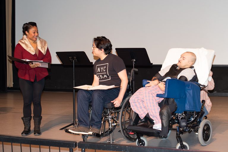 Arts Access writer Luis Rodriguez performing on stage with two actors at the Robert Schonhorn Arts Center during the 2023 Plays by People performance.