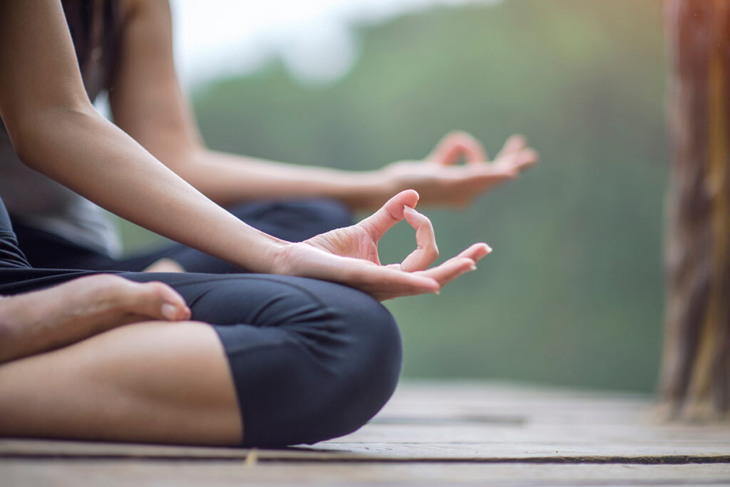 close-up of people doing yoga outside