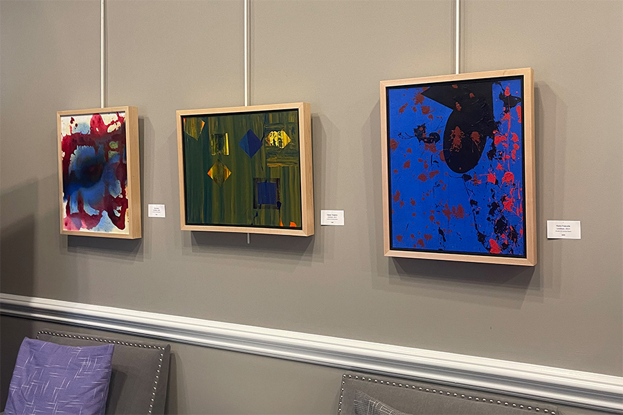 Abstract acrylic paintings hanging on a gallery wall.