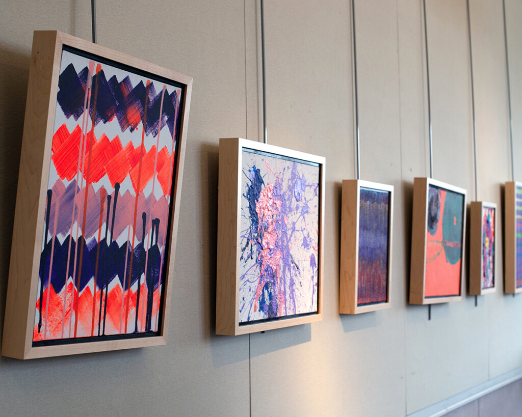 Abstract acrylic paintings hanging on a gallery wall at the Robert Schonhorn Arts Center for Full Circle 2023.