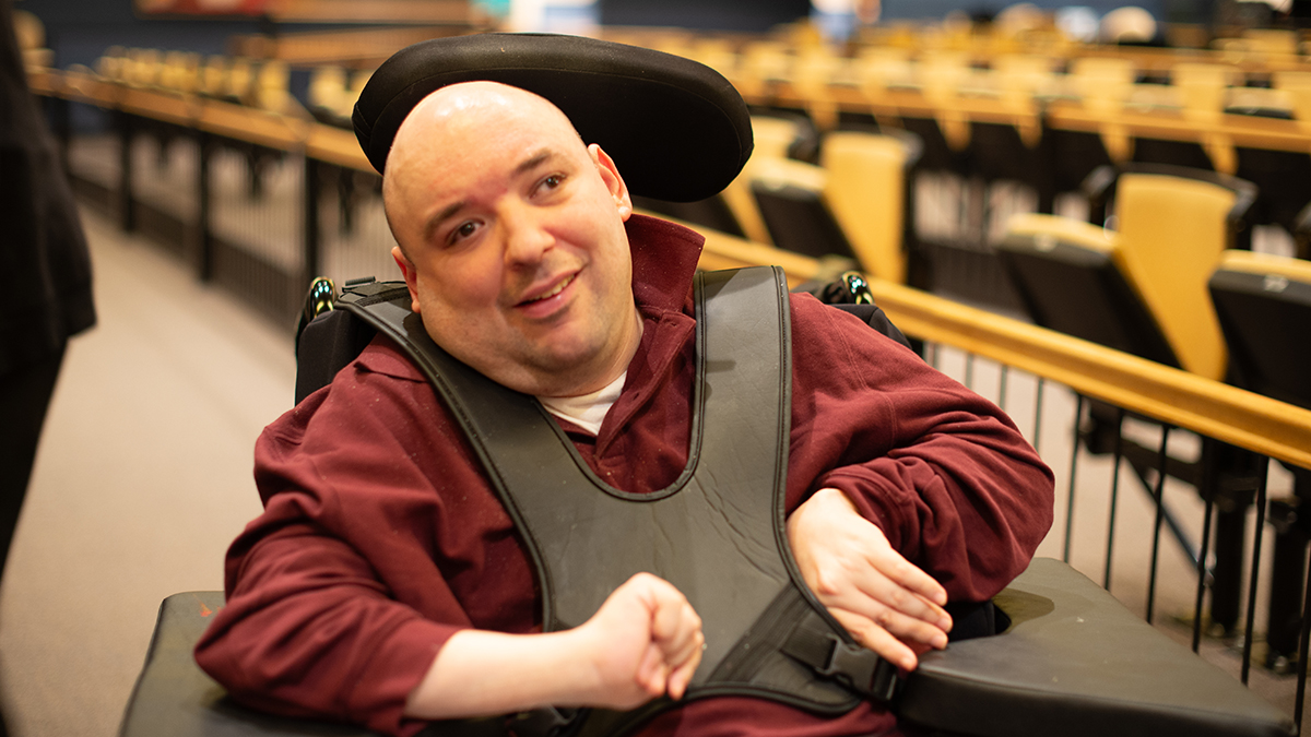 Paul Santo sitting in his wheelchair in the Arts Access auditorium.