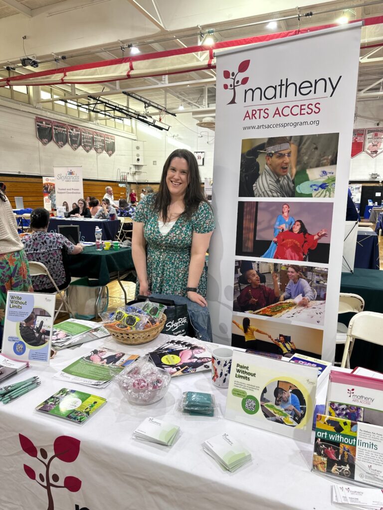 Matheny table full of promotional items, brochures, and postcards at a resource fair in a school gymnasium.