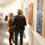Full Circle 2019 guests viewing paintings on display in the Robert Schonhorn Arts Center gallery.