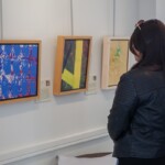 Full Circle 2019 guest viewing paintings on display in the Robert Schonhorn Arts Center gallery.