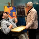 Artist Thomas Christian by his displayed painting at Access-ABILITY 2020.